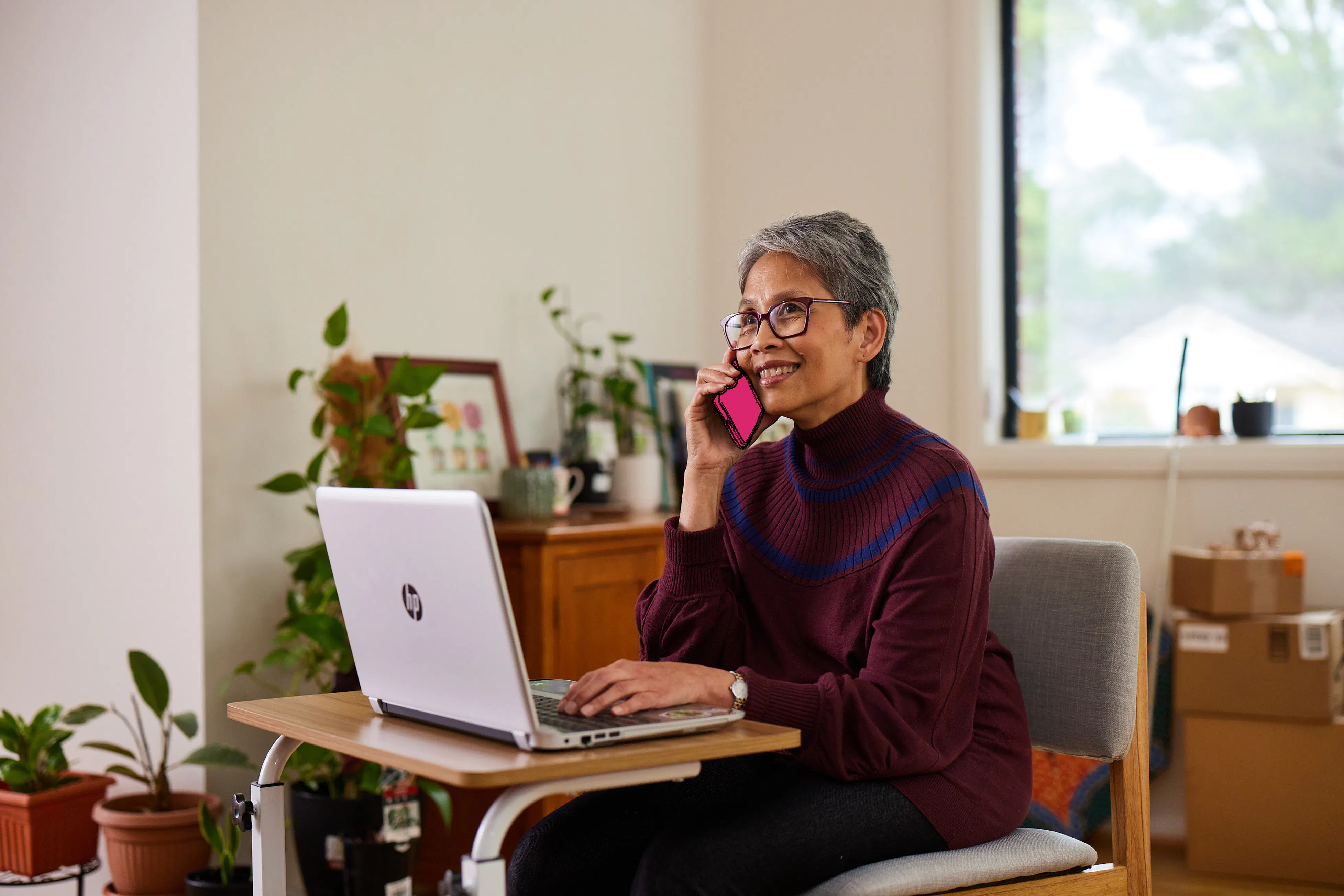 A Hireup client smiling as she talks to a support worker on her phone.