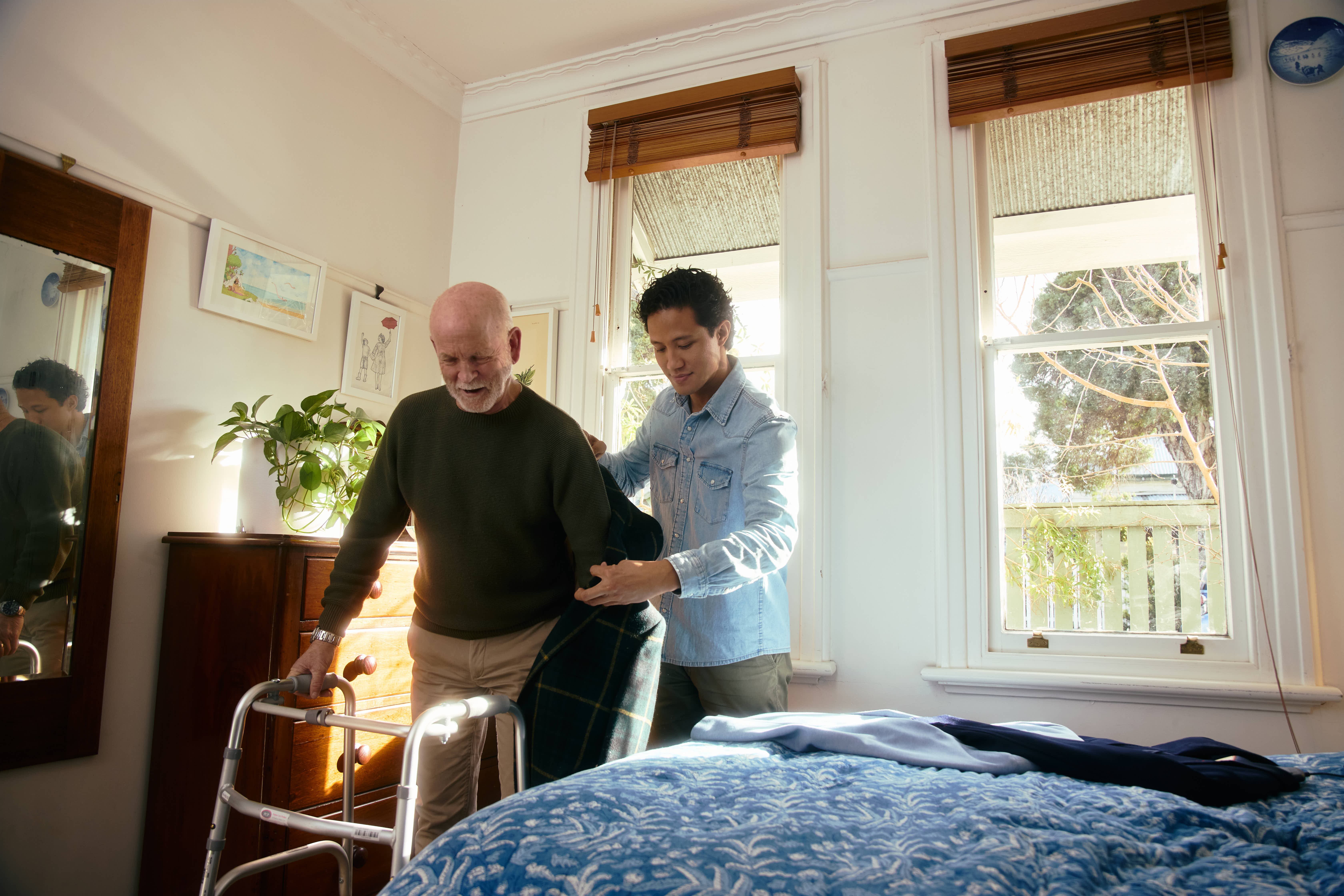 Hireup support worker Karl helps client Bill get dressed.