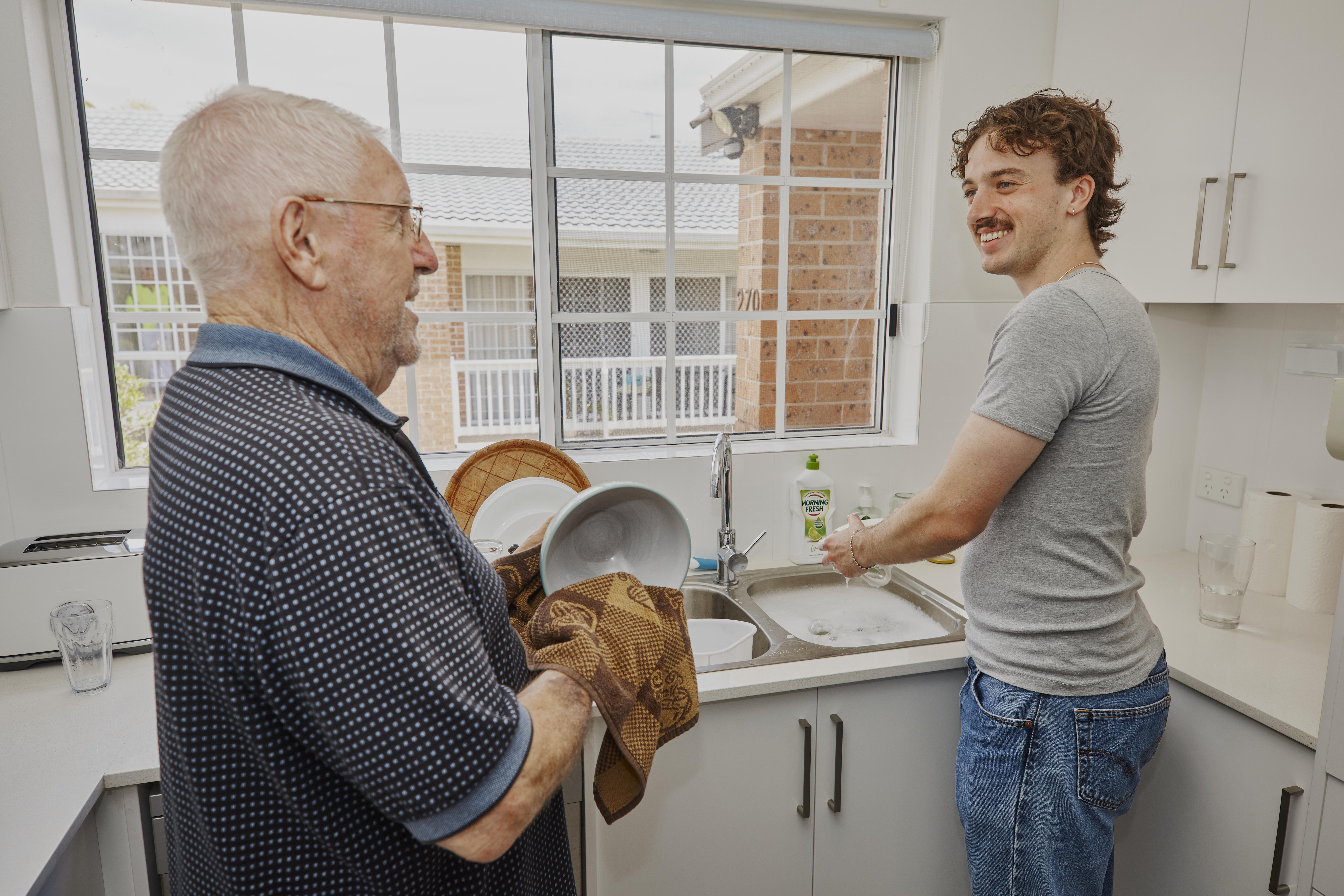 Hireup support worker Luka helps client Frank wash the dishes.