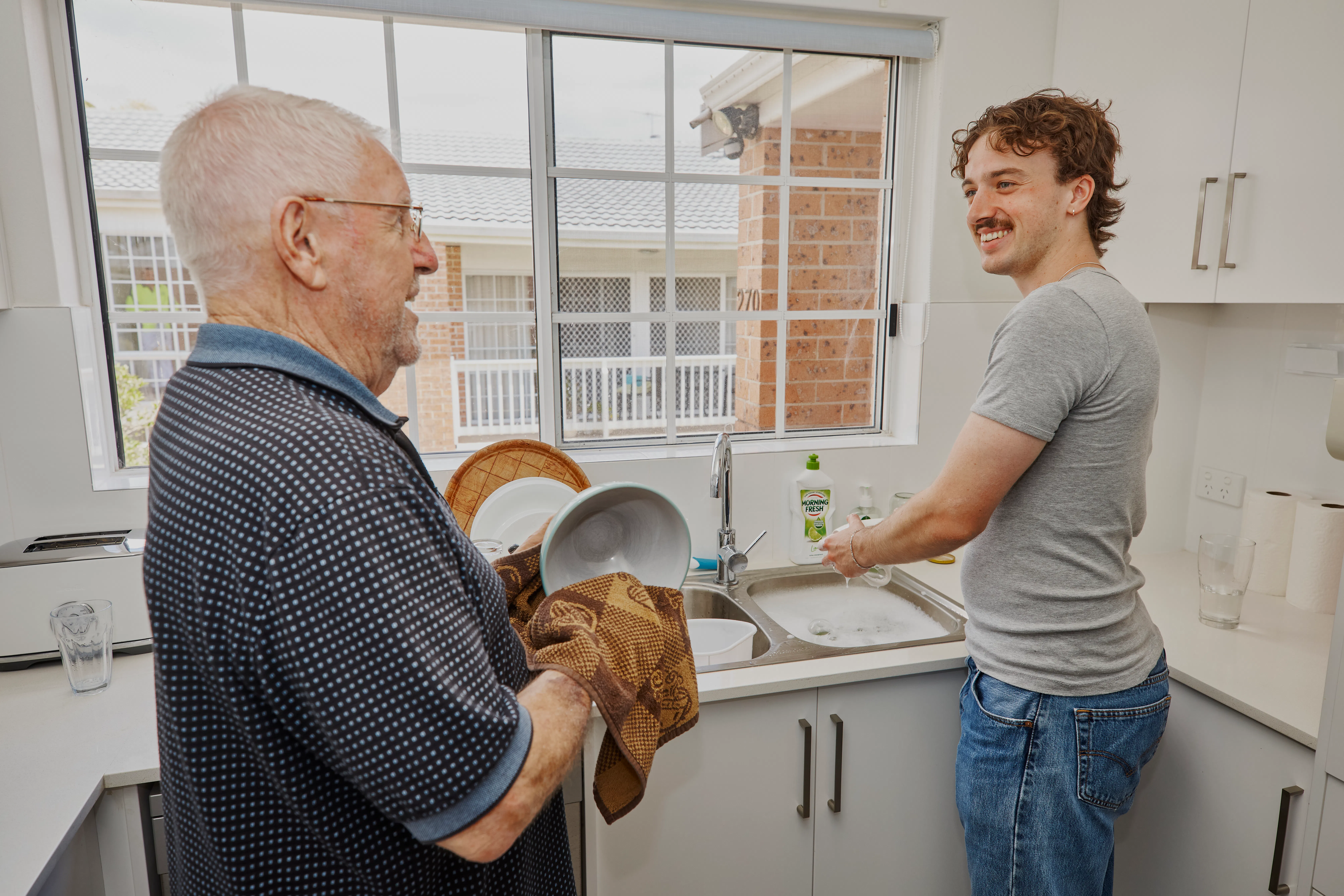 Hireup support worker Luka helps client Frank wash the dishes.