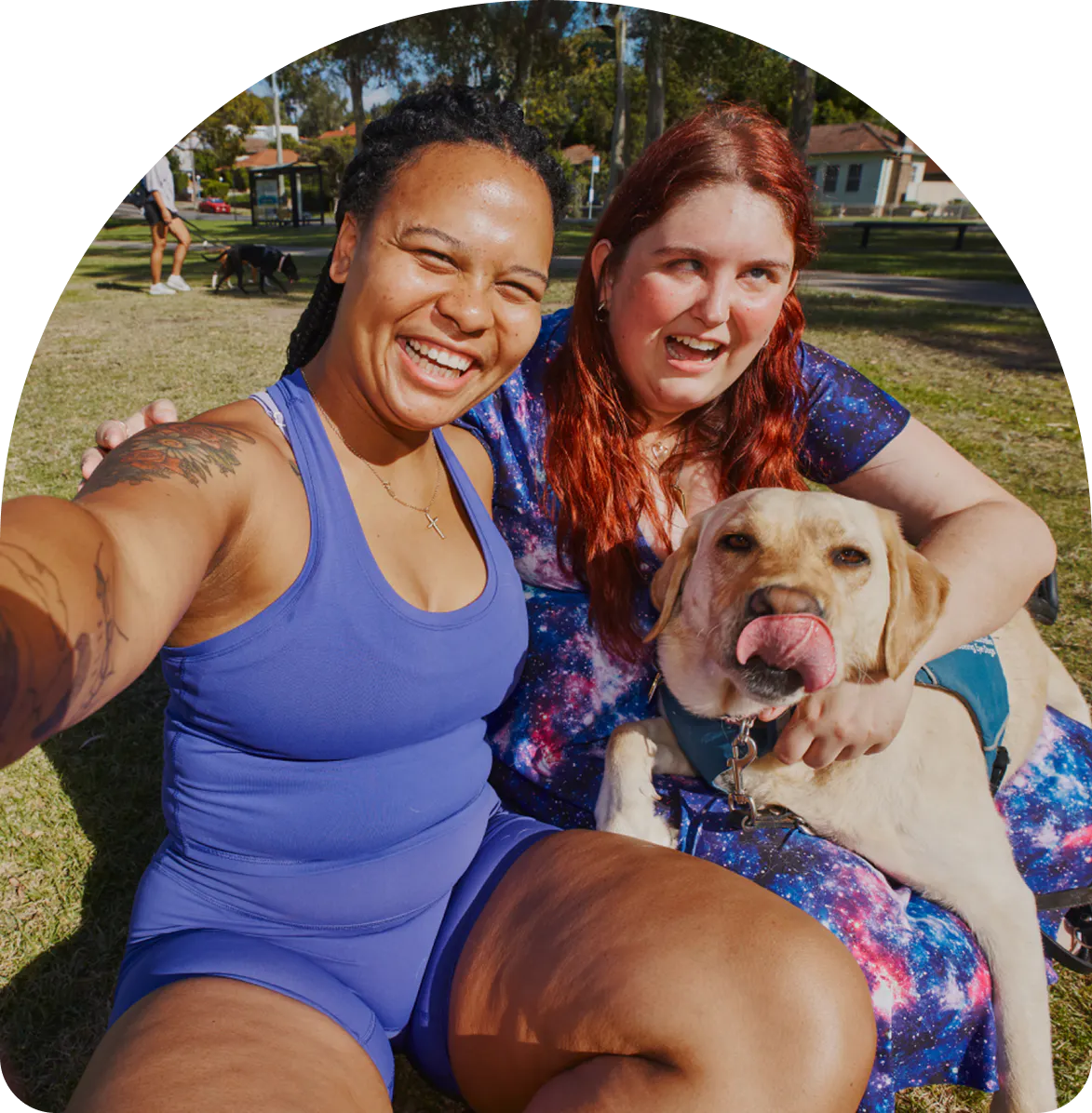 Hireup client Kirsten smiles with her support worker Paulla and her guide dog in the park.