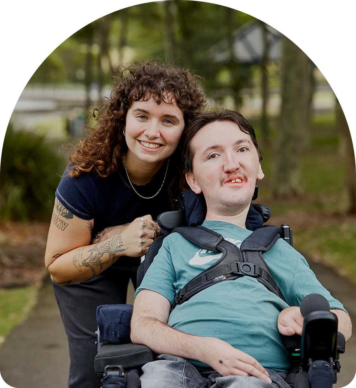 Hireup client Tom smiles at the camera with support worker Sarah.