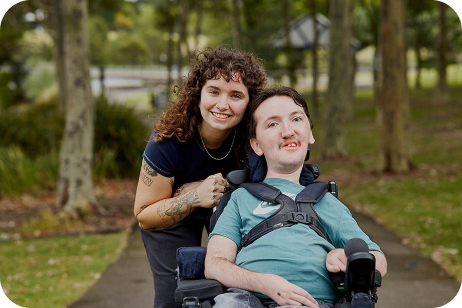 Hireup client Tom and support worker Sarah smile at the camera.
