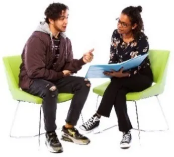A man and a woman on chairs looking at a document. The man is talking and the woman is listening.