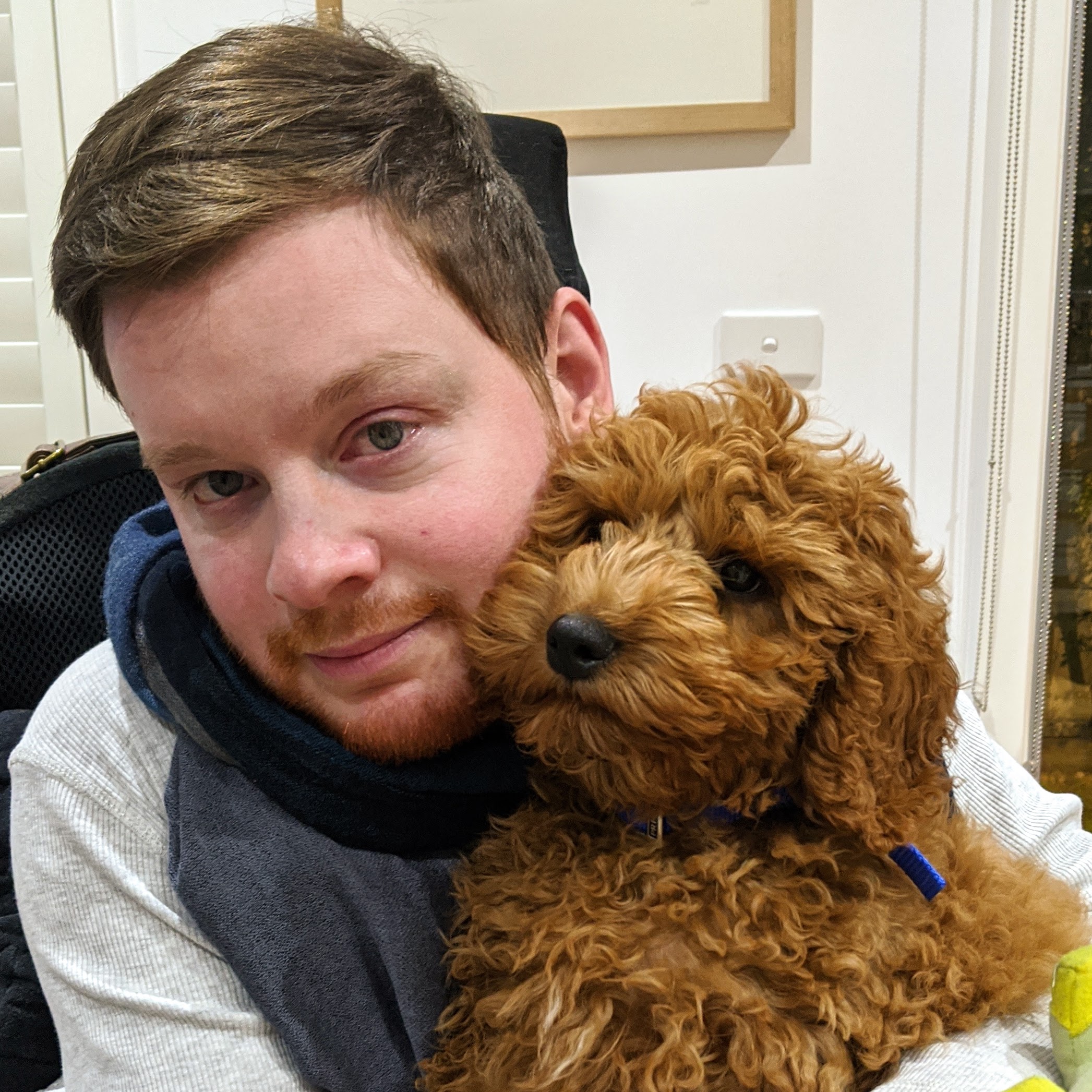 Carl Thompson snuggles with his dog, Oscar, while sitting in his wheelchair. 