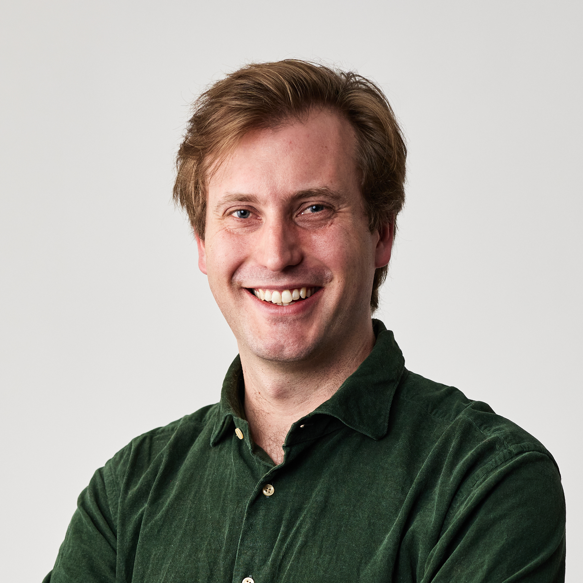 Peter Willis, Hireup's CEO, has short, brown hair and is wearing a dark, green corduroy shirt. He's smiling, with his arms folded, in front of a white wall.