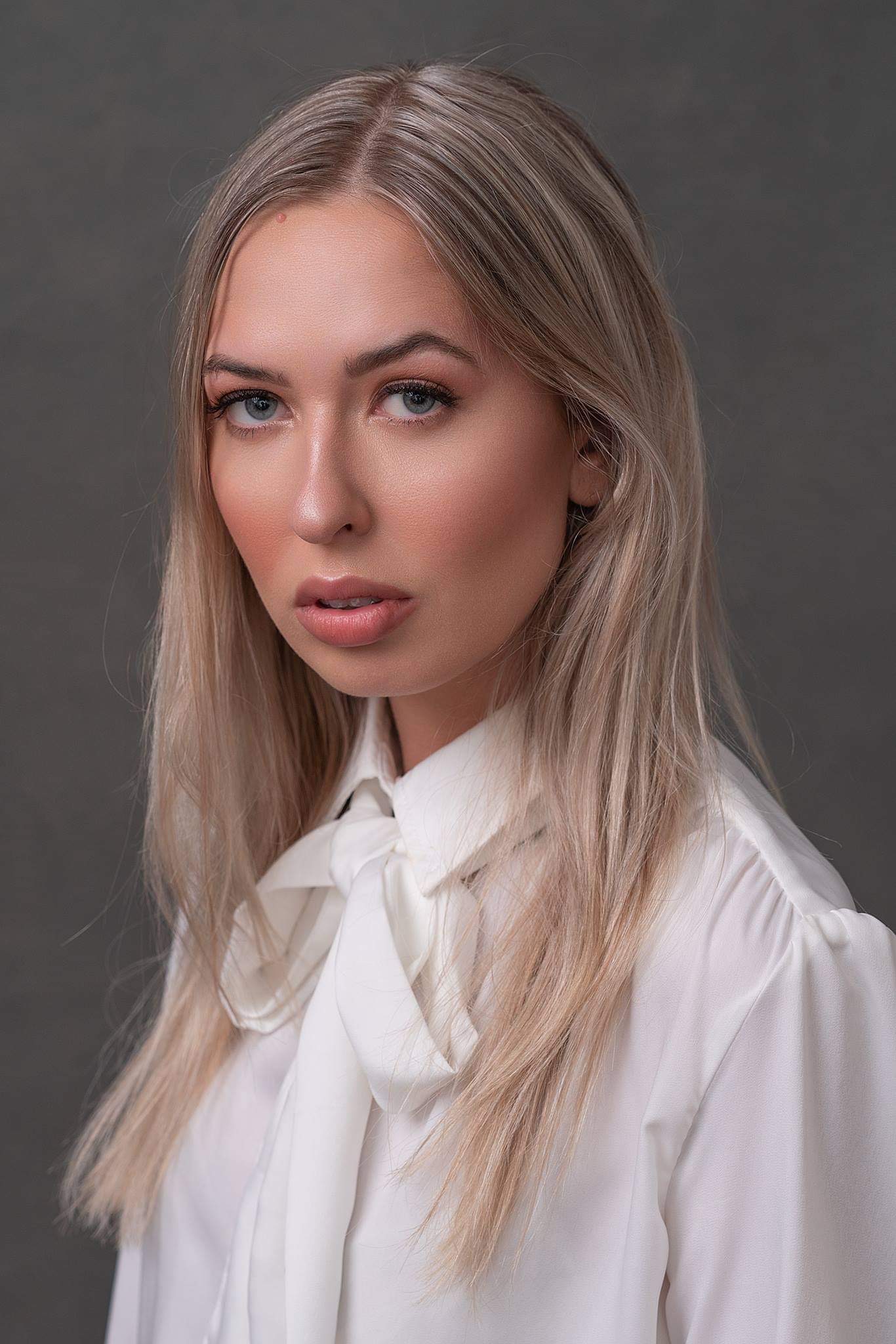Anja Christoffersen, disability advocate and editor of&nbsp;In Crowd magazine, has long blonde hair and wears a white shirt with a bow tied loosely. 