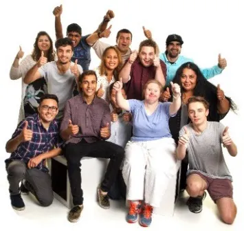 A large group of people smiling with thumbs up.