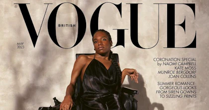 Aaron Rose Philip, a Black Transgender power wheelchair user with black braids in a ponytail, on the cover of British Vogue. Aaron Rose is positioned against a grey, textured background, wearing a long black silky dress with a halter-neck by Del Core, with black ballerina pumps by Miu Miu and jewellery by Alexander McQueen and Hermès. Behind her head, a black Vogue logo in big letters. The cover also reads ‘Reframing Fashion: Dynamic, Daring & Disabled.’