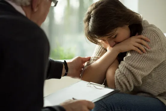 A man trying to comfort a woman, putting his hand on her arm