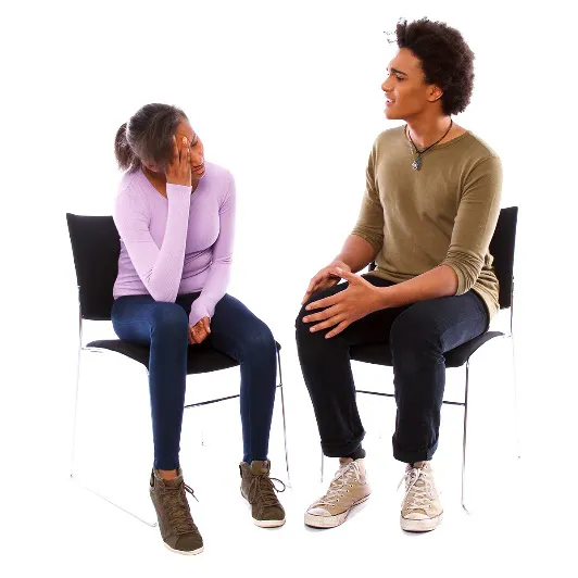 A man and a woman sitting down together and talking 