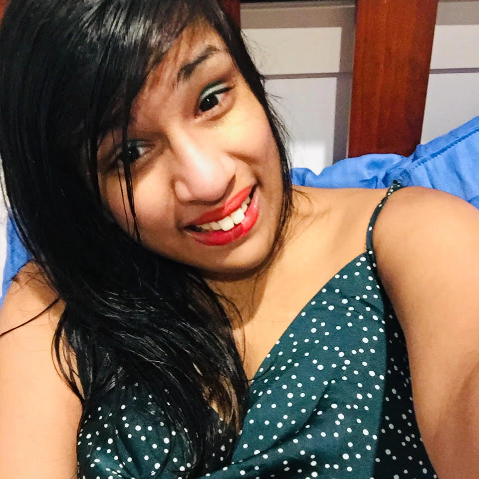 Jerusha is smiling at the camera. She is taking a selfie.