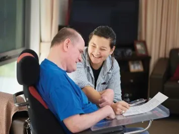 A woman supporting a man with a disability.
