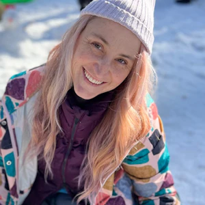 Disability advocate Holly Karten has long blonde hair and wears a pink beanie and colourful jacket. She smiles at the camera.