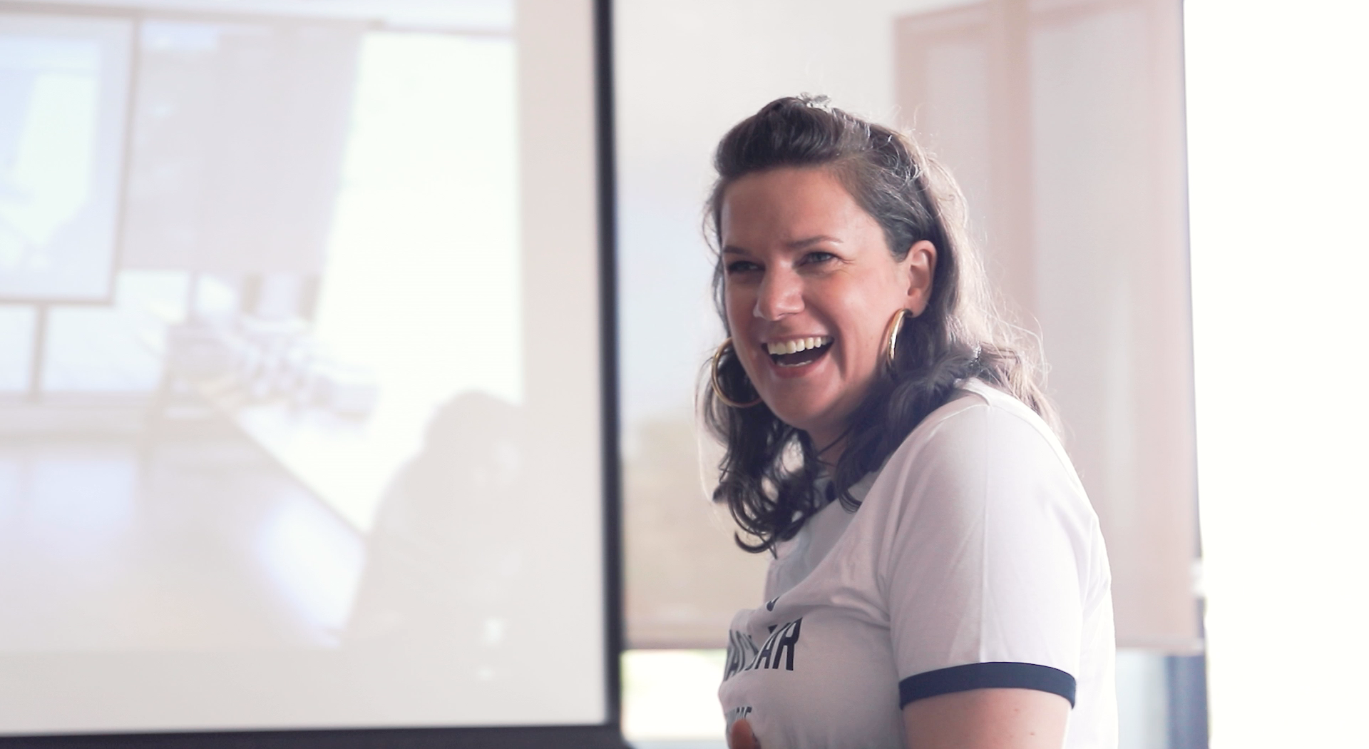Harriet Dwyer, Hireup's Director of Impact & Innovation looks in the distance smiling.