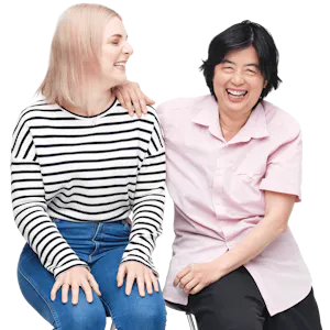 A support worker and Hireup user, seated, smiling.