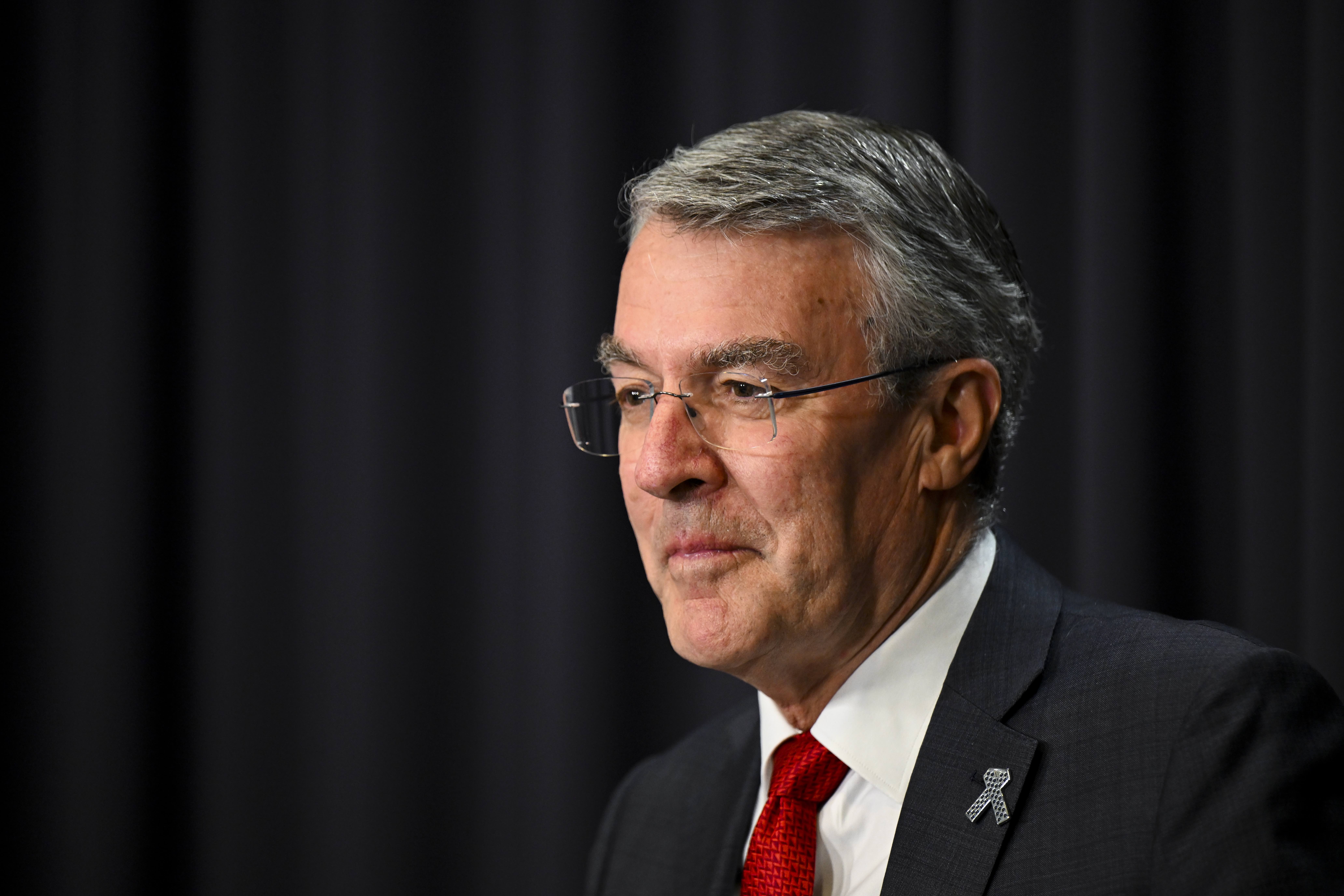 Attorney General Mark Dreyfus looks to his right. He wears a suit and has glasses 