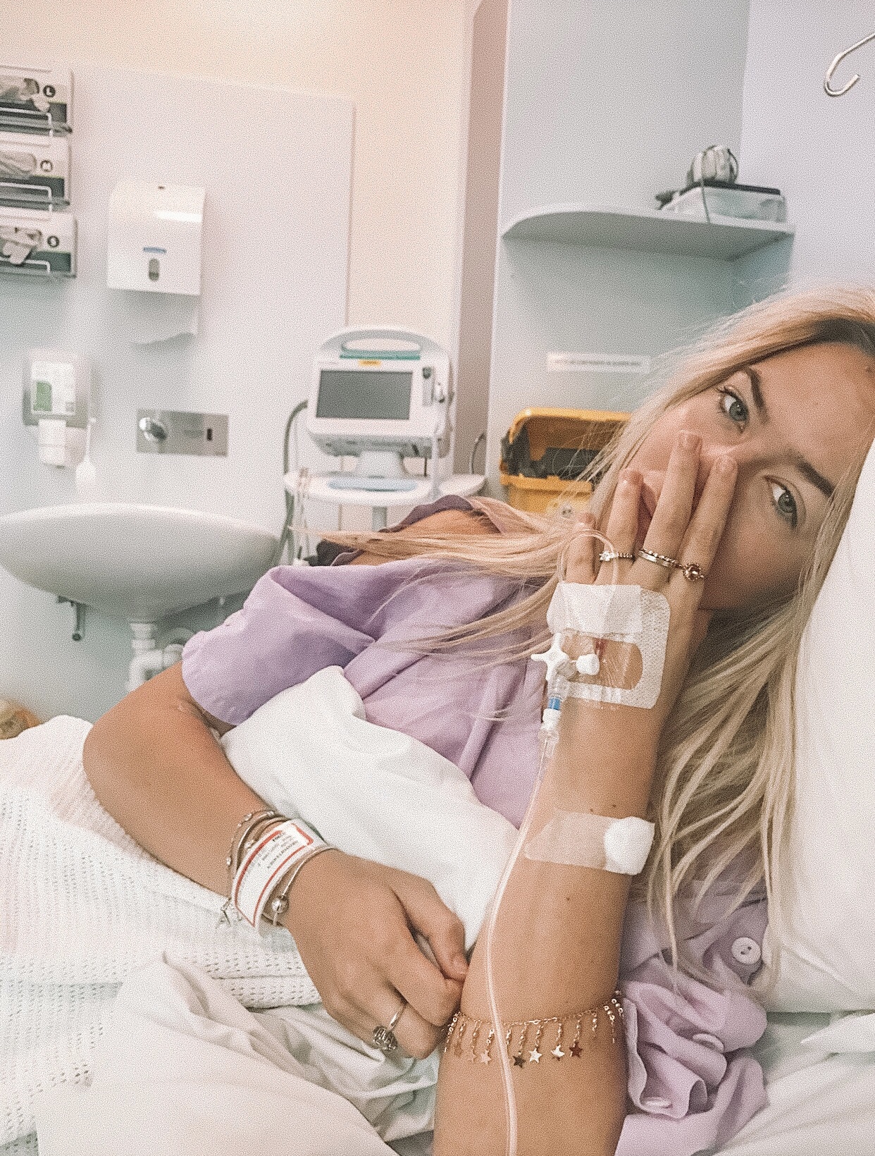 Anja Christoffersen is lying on a hospital bed with cannulas and drips and monitors attached to her. 