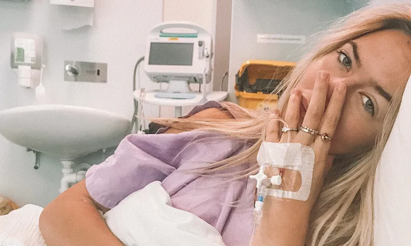 Anja Christoffersen is lying on a hospital bed with cannulas and drips and monitors attached to her.