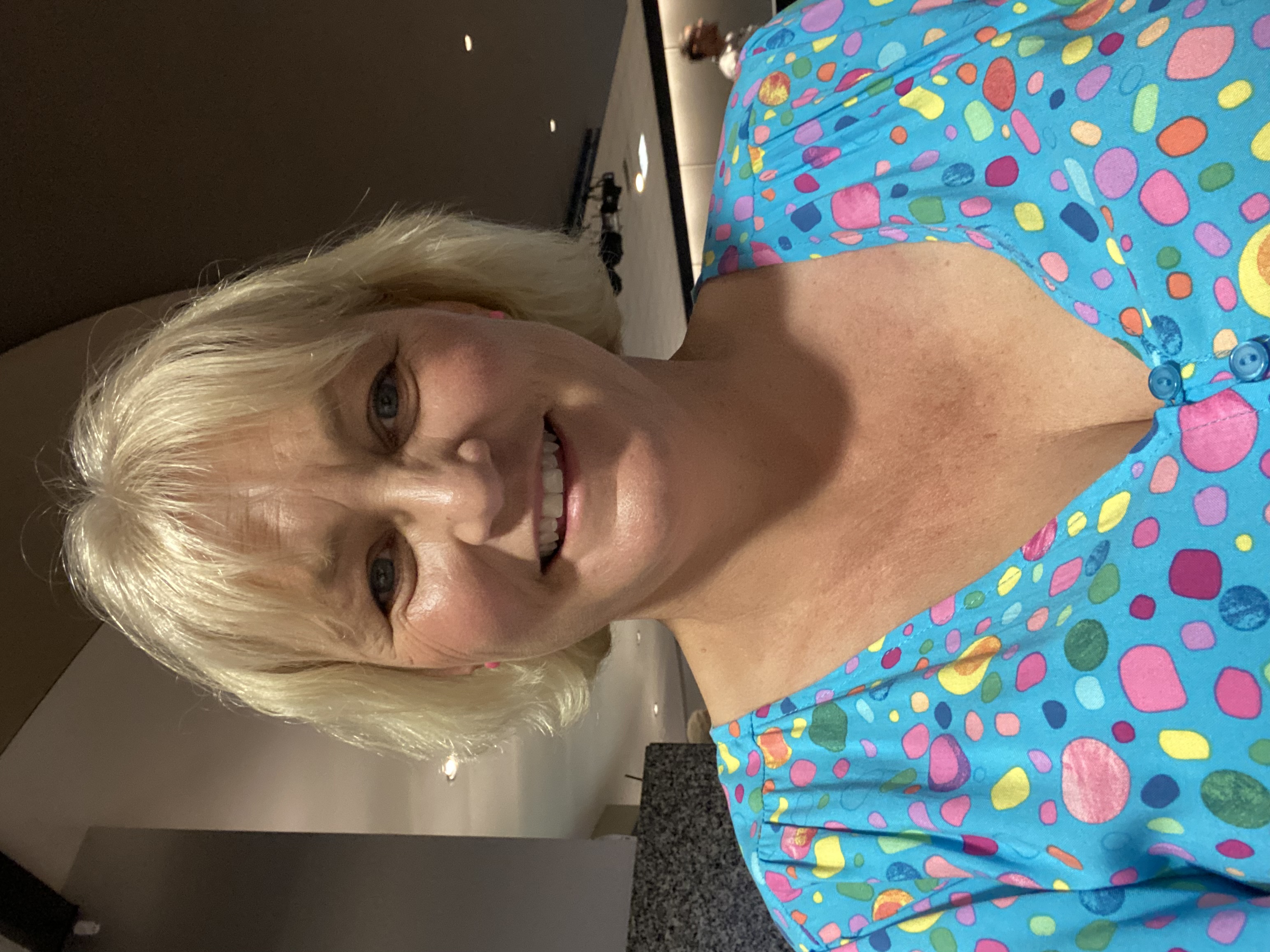 Podcaster and sleep consultant Mandy Hose has a blonde bob and wears a colourful polkadot top. She smiles at the camera.