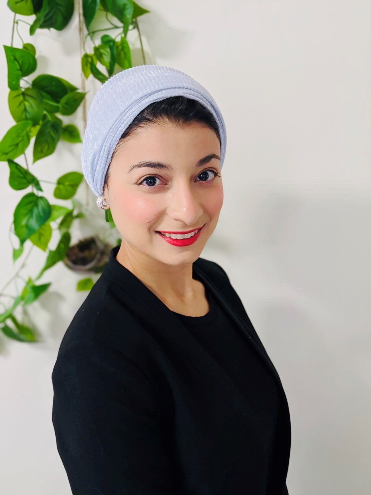 Dietitian Lina Breik wears a headscarf over her dark hair and smiles at the camera. A plant hangs in the background.