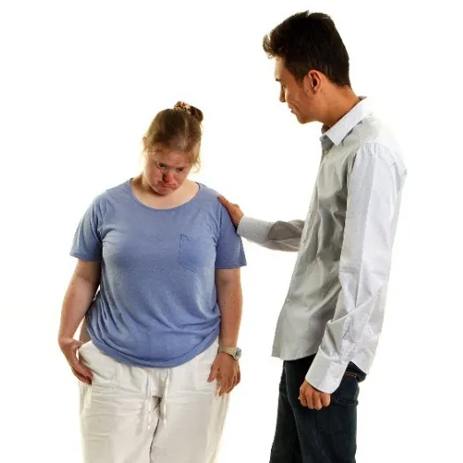 A man supporting a woman, who is looking down