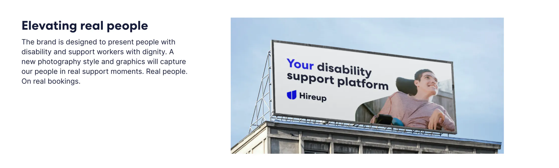 A billboard is above a building. On the billboard, a young man sits in a wheelchair and smiles, and  the text "Your disability support platform" with the Hireup logo is next to his photo on the billboard.  