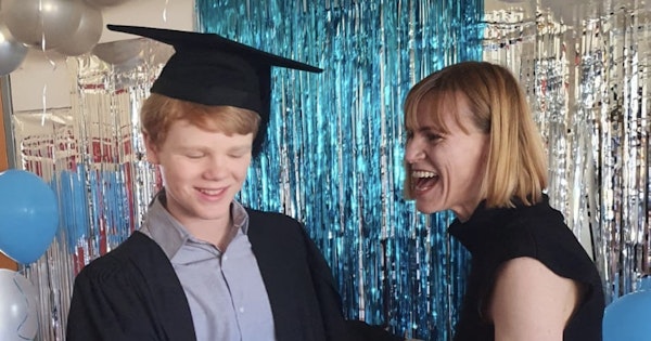 Author, Briana Blackett, with her son at his primary school graduation. Both are laughing.