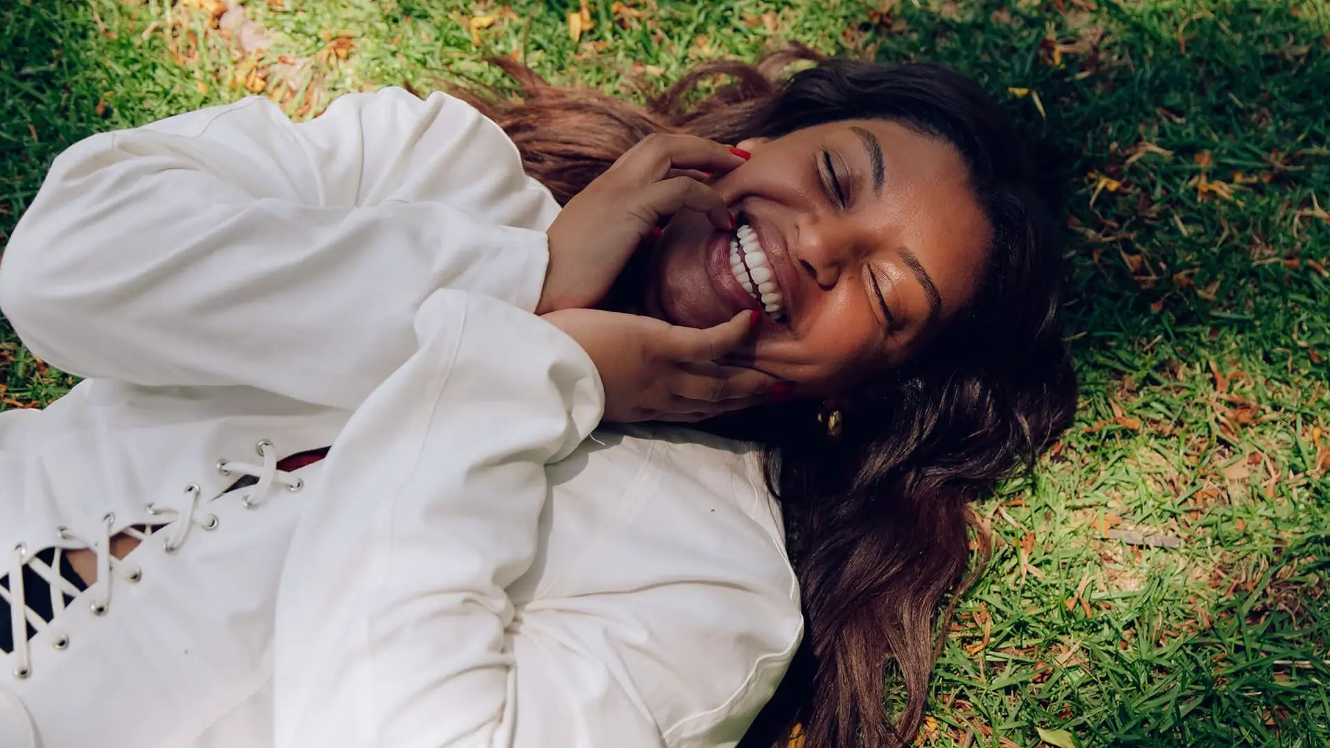 A smiling woman laying in the grass