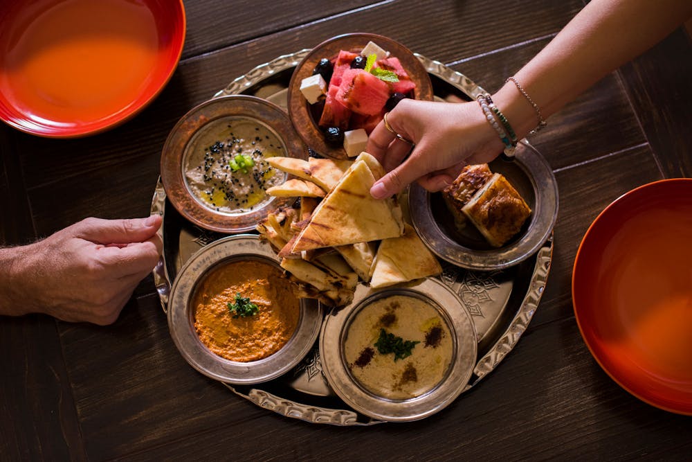 Image of two hands reaching for Turkish food appetizers on a table