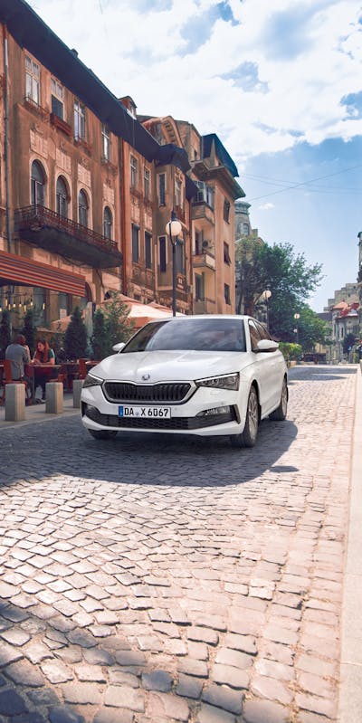 Weißer Skoda Scala fährt durch die Stadt