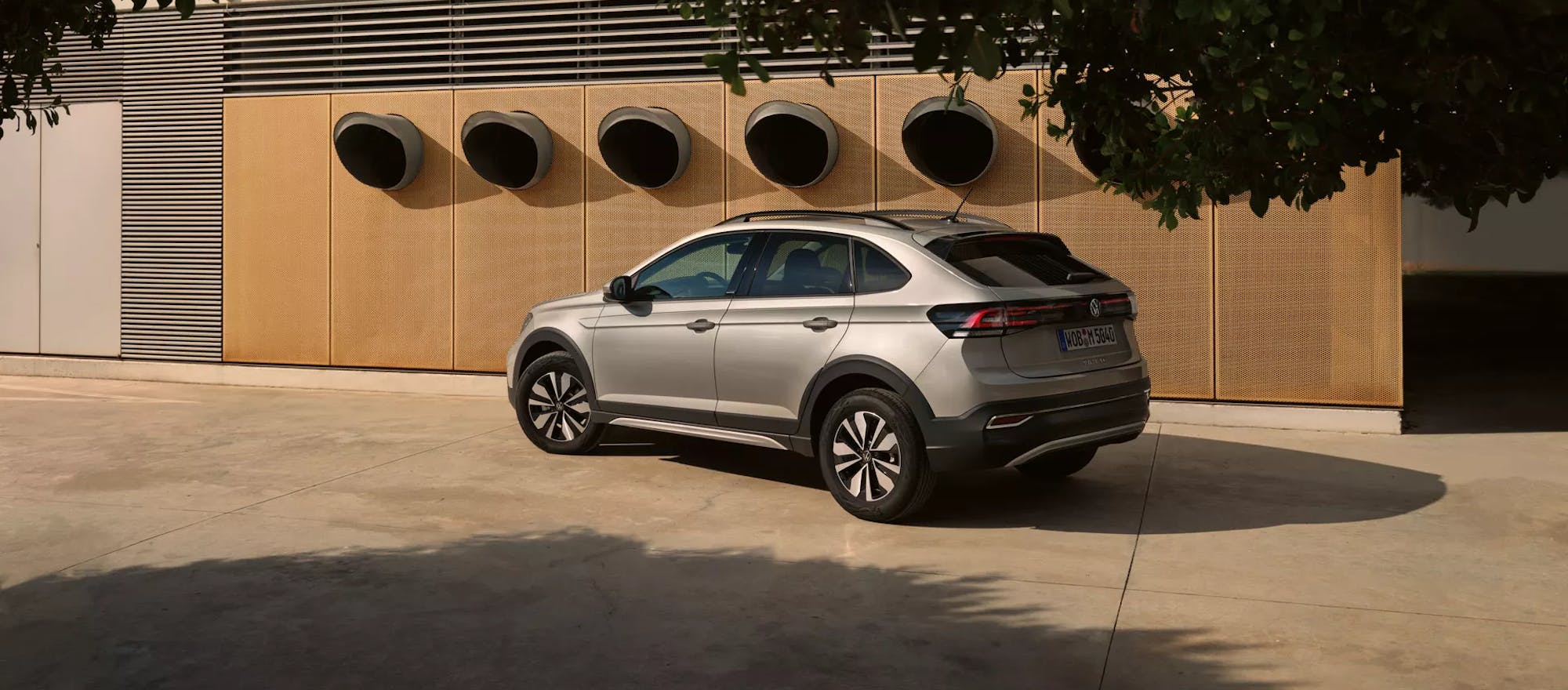 Vor Gebäude geparkter VW Taigo in silber