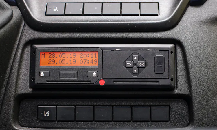 Digitaler Fahrtenschreiber im Nutzfahrzeug-Cockpit mit beleuchtetem Display, Datums- und Uhrzeitanzeige sowie zwei Kartenschächten für Fahrerkarten