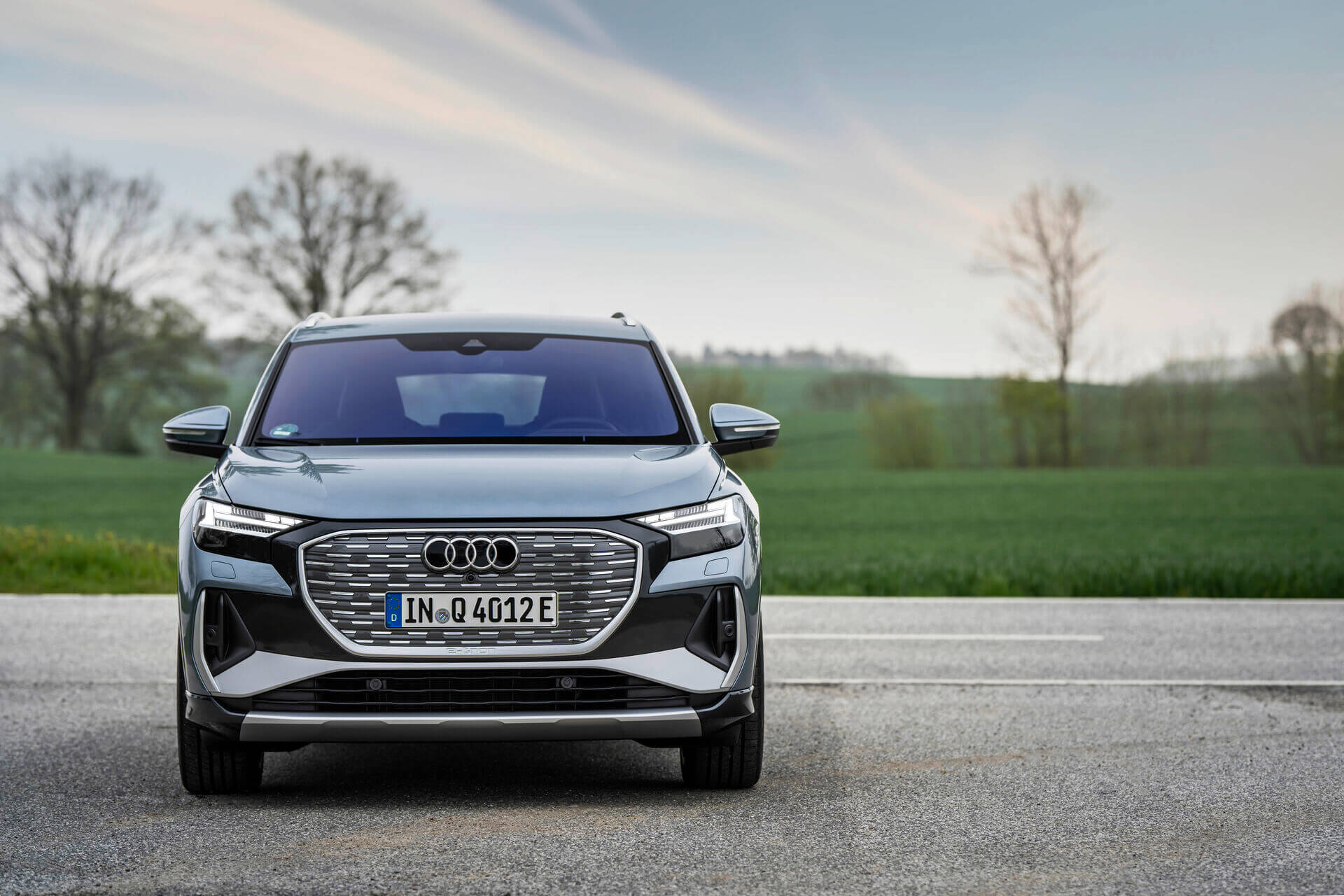 Audi Q4 e-tron in Geysirblau – vollelektrisches SUV in der Frontansicht auf Landstraße