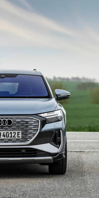 Audi Q4 e-tron in Geysirblau – vollelektrisches SUV in der Frontansicht auf Landstraße