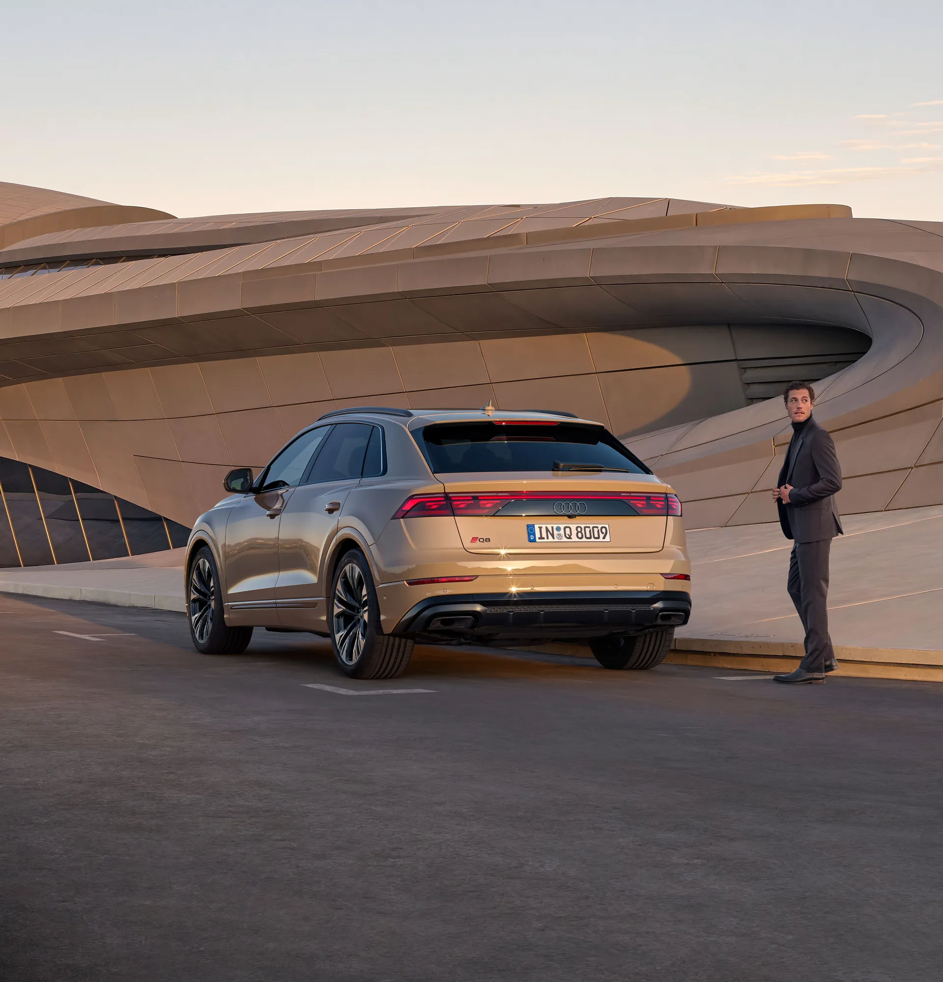 Frontansicht eines fahrenden Audi Q8 mit Bergen im Hintergrund