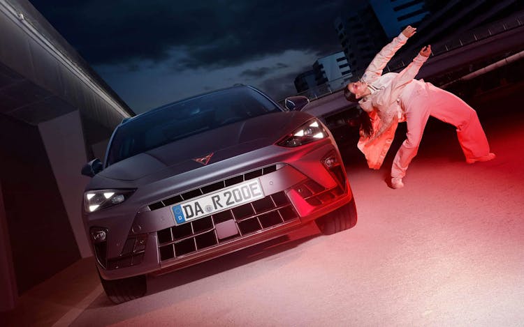 Frontansicht des CUPRA Leon mit tanzender Person daneben
