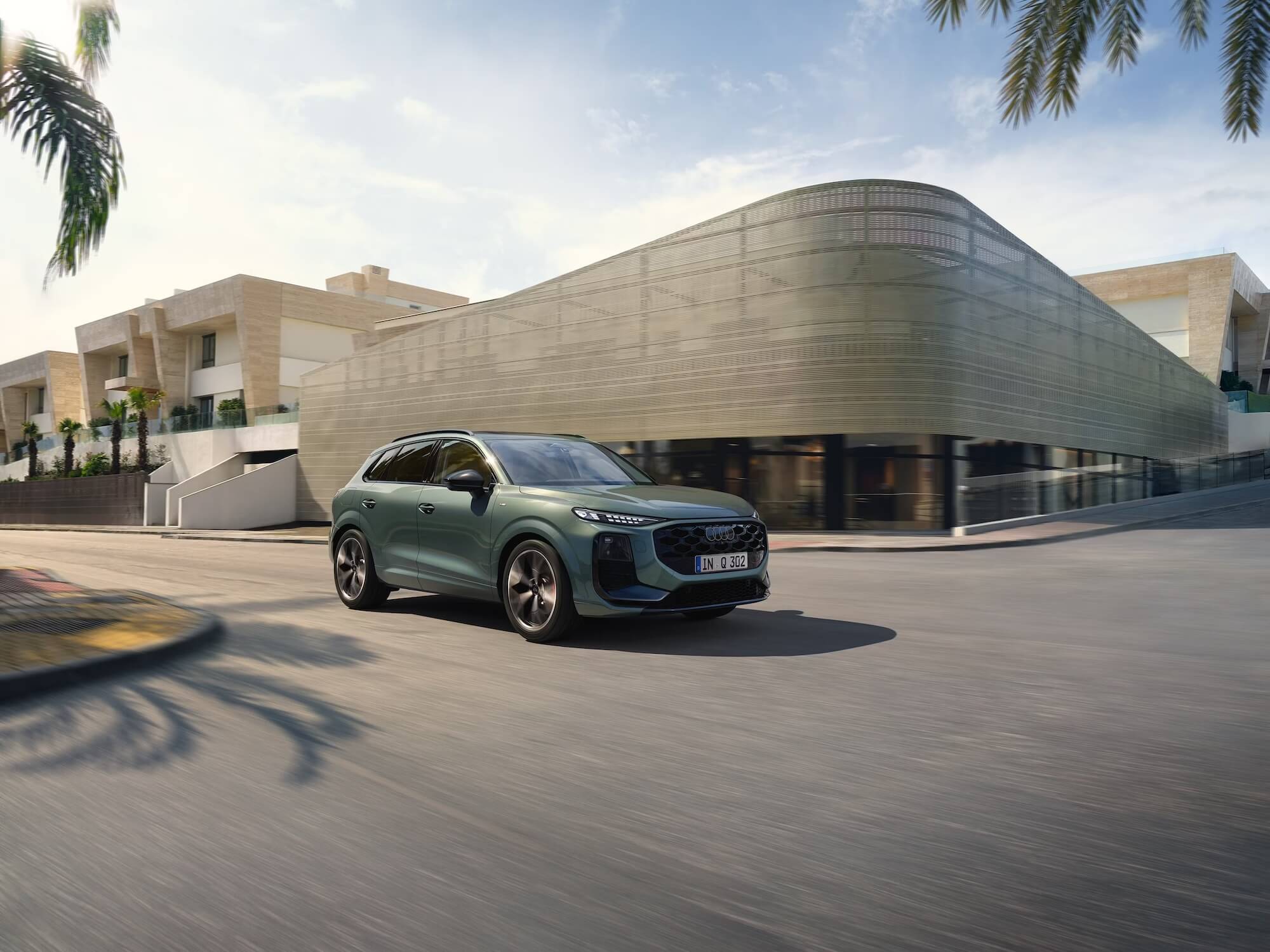 Audi Q3 fährt in urbaner Umgebung vor einem modernen Gebäude