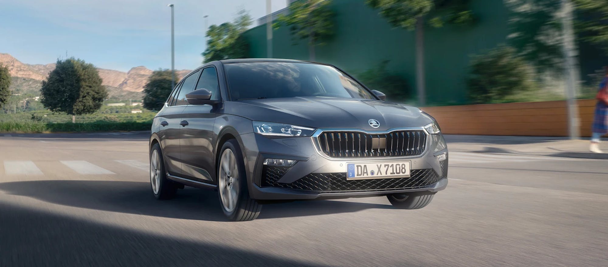 Frontansicht eines über die Straße fahrenden Skoda Scala