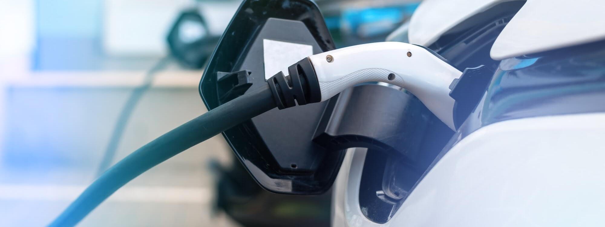 Detailaufnahme eines Elektroautos beim Laden mit Ladekabel