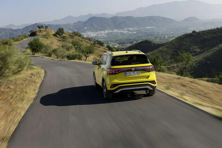 Gelber VW T-Cross während der Fahrt (Heckansicht)