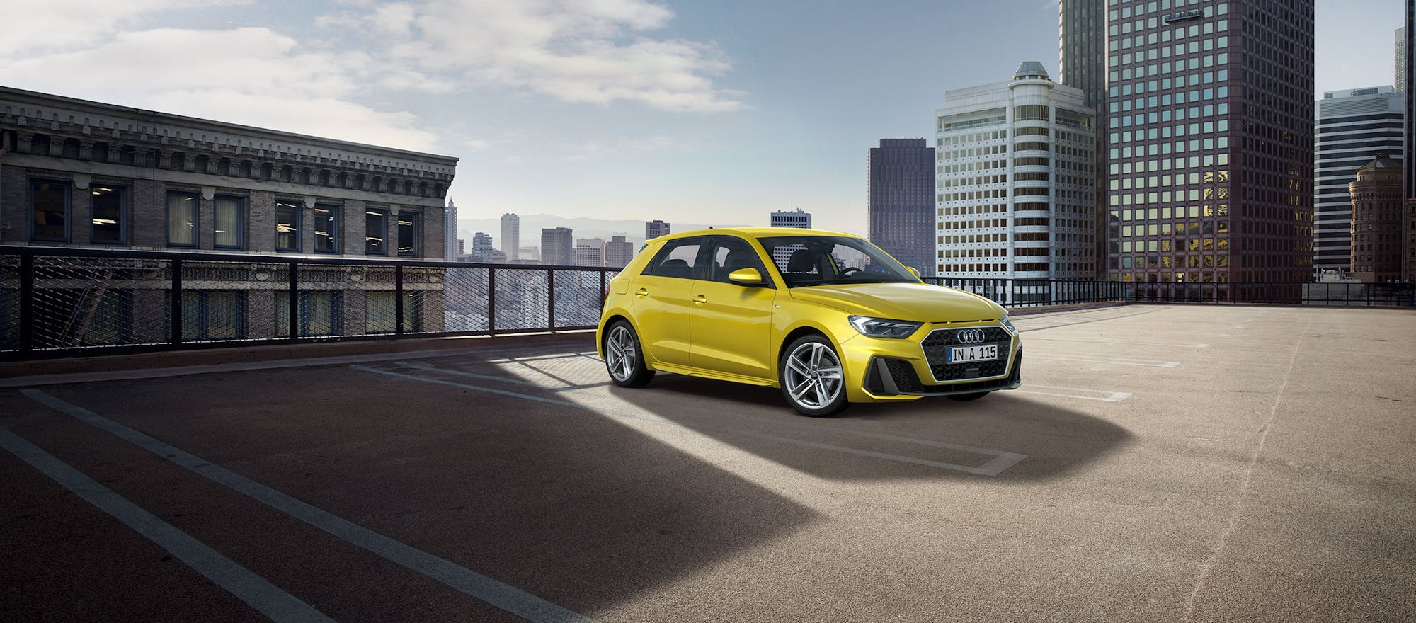 Gelber Audi A1 auf Dach geparkt mit Skyline im Hintergrund