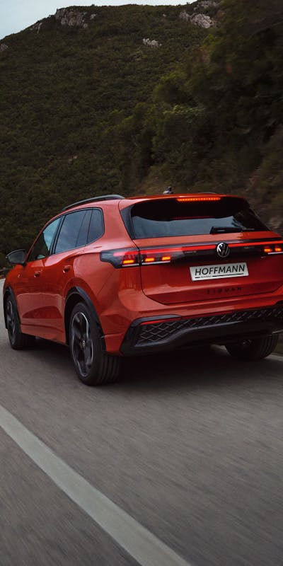 Heckansicht eines roten VW Tiguan während der Fahrt