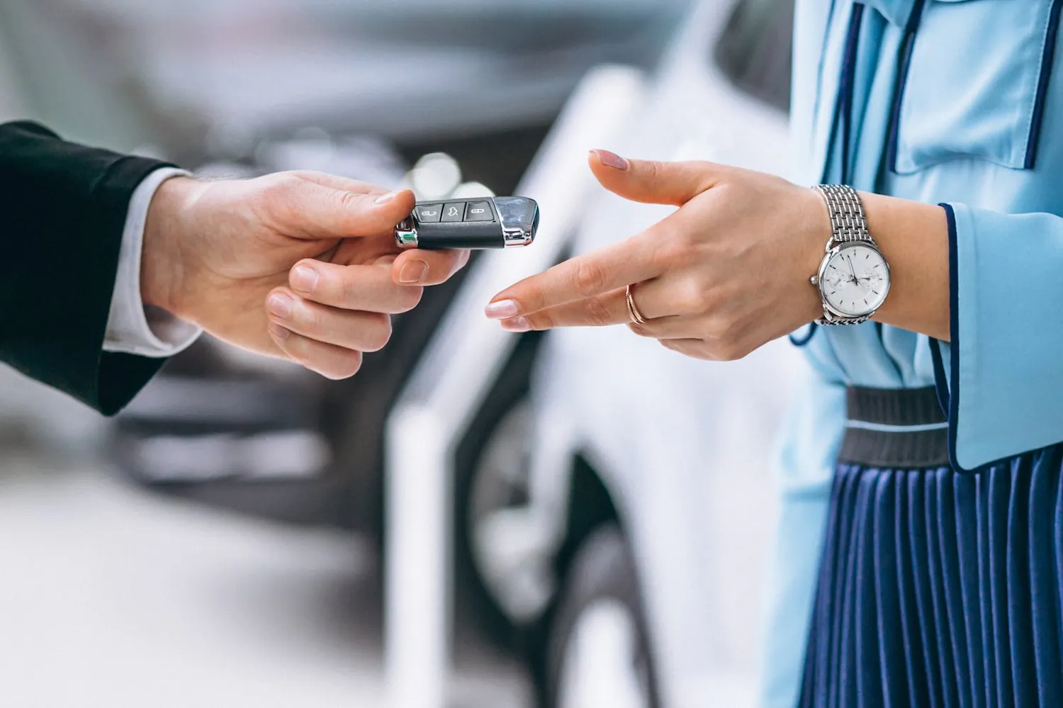 Nahaufnahme einer Fahrzeugschlüsselübergabe zwischen Verkäufer und Käufer – Elektroautos, Hybrid und Diesel beim Autohaus Hoffmann