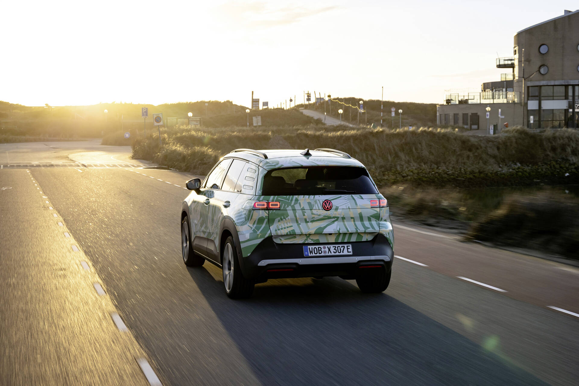 Neuer VW ID Cross Prototyp mit Tarnfolierung bei Testfahrt in Küstenlandschaft bei Sonnenuntergang