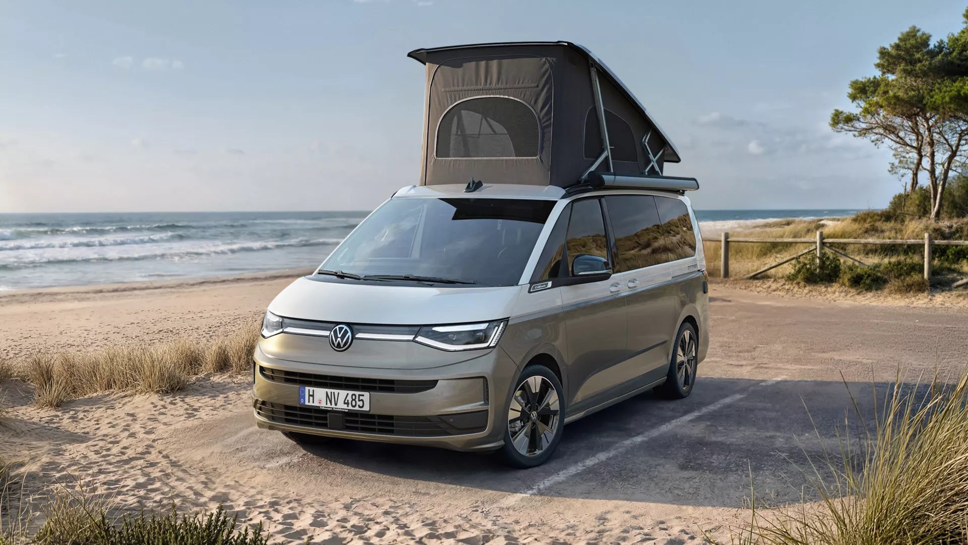 VW California mit ausgeklapptem Aufstelldach an einem Strand geparkt