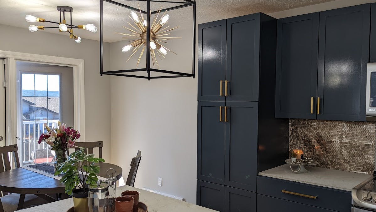 Chic lighting in kitchen and dining room with gray/blue cupboards