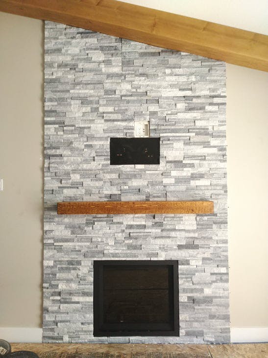 White and slate tiled fireplace with large solid wood shelf