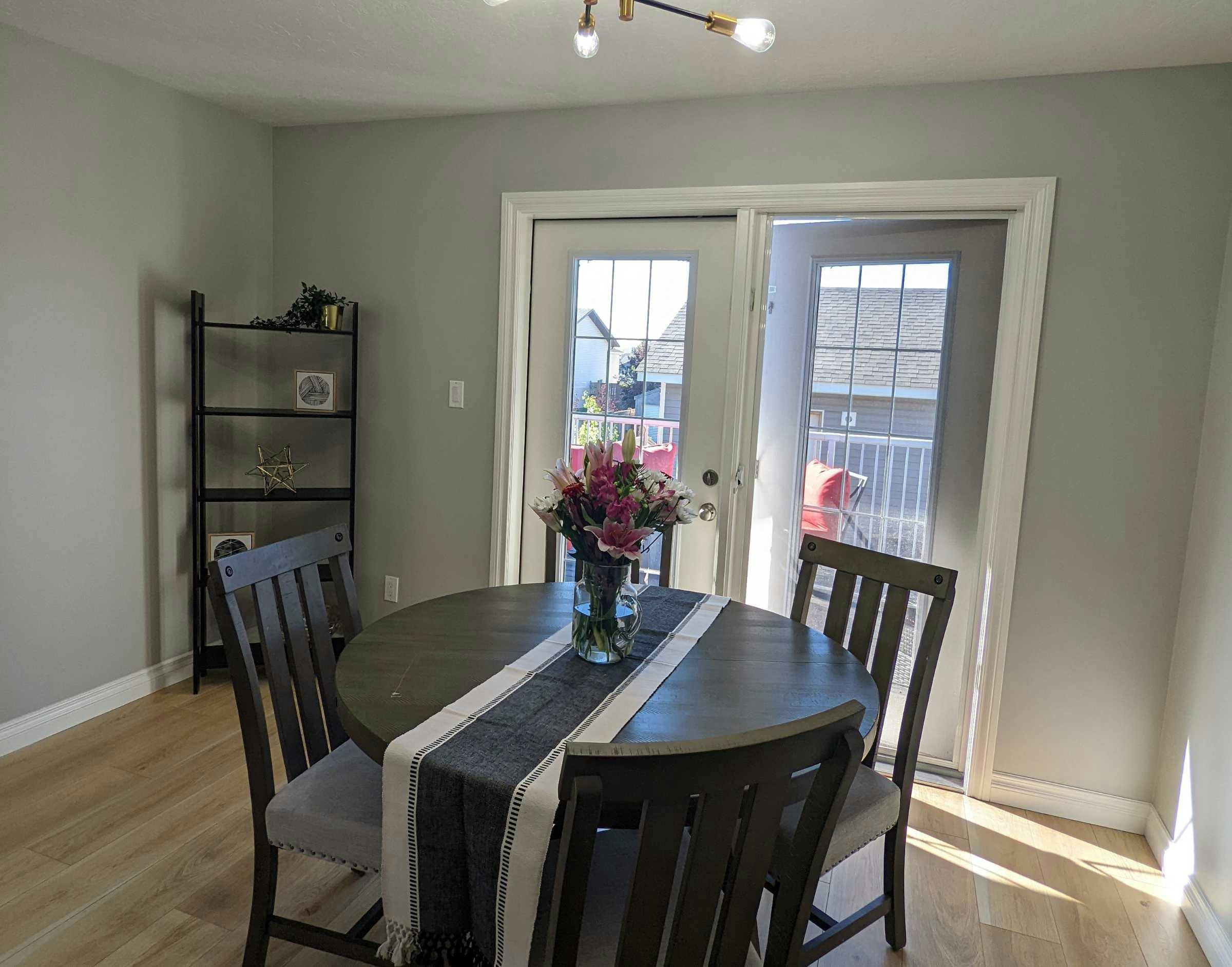 Staged dining room table with table runner and fresh pink and white flowers