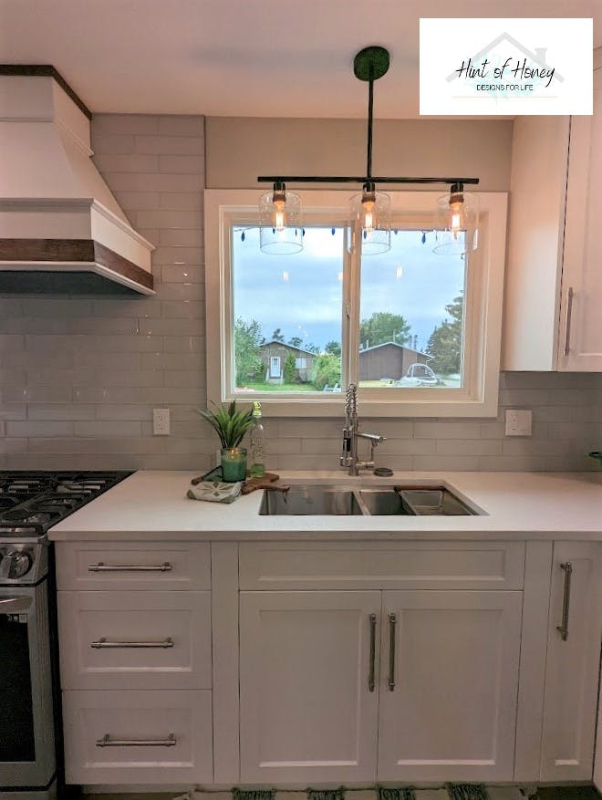 Kitchen sink with chic lighting and window letting in natural light